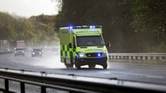 photo of British ambulance responding to an emergency in hazardous driving conditions due to bad weather on a British highway