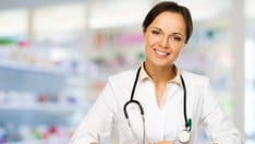 photo of Doctor's wife in the pharmacy. Young, positive brunette doctor's wife behind the counter in the pharmacy.