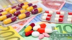 photo of Healthcare costs. Assorted pills and capsules above euro money