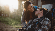 photo of a woman caring for a man in a wheelchair