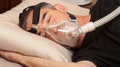 photo of Sleep apnea and CPAP. Man suffering from sleep apnea and using a CPAP machine