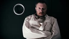 photo of Crazy man in a cell wearing a straitjacket. 