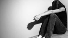photo of Young woman suffering from severe depression (very harsh lighting is used on this shot to emphasize/give the dark mo