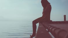 photo of Woman sitting at sea experiencing depression and headaches