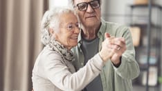 photo of Portrait of a happy senior couple dancing and having fun at home.