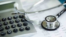 photo of Calculator and stethoscope on a financial statement concept for a financial health check or healthcare cost