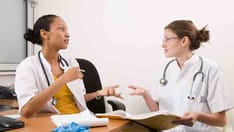 photo of Medical discussion. Two young medical students discussing a case together