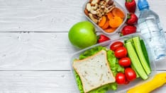 photo of School lunch boxes with sandwich and fresh vegetables