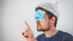 photo of The concept of conspiracy theory: The angry young man's hood and the aluminum mask worn over his eyes are making ang