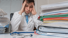 photo of Bureaucracy in medicine concept Tired overloaded doctor have a lot of documents on the desk