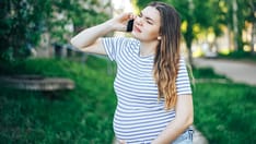 photo of Pregnant woman experiencing contractions and calling for help. Pregnant woman with painful contractions calling an a