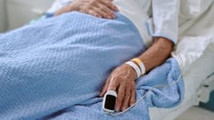 photo of Elderly woman resting in a hospital bed with a pulse oximeter attached. Elderly woman lying in a hospital bed, resti