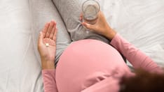 photo of pregnant woman taking pills
