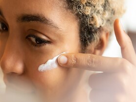photo of person applying lotion to face.