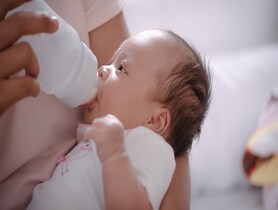 photo of an infant drinking a bottle