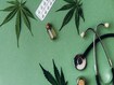 photo of cannabis leaves, THC oil, and stethoscope