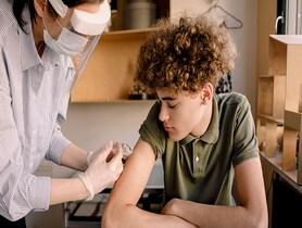 photo of teenage boy getting vaccinated