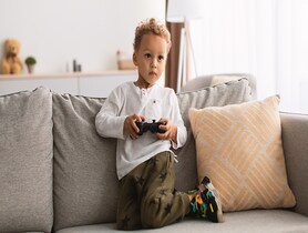 photo of child playing videogames