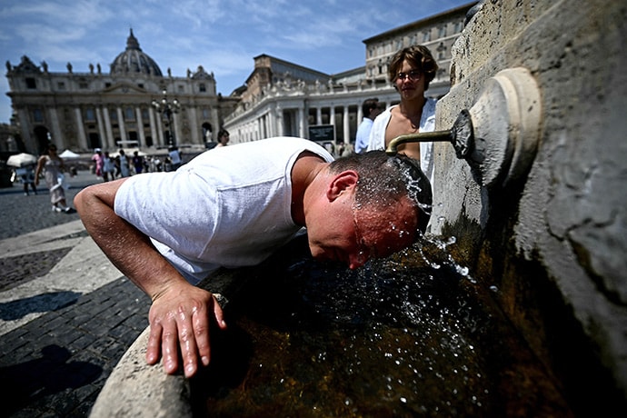 photo of A man cools off at a fountain in St.Peter's Square at the Vatican on August 13, 2025.