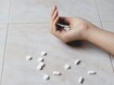 photo of a hand and spilled pills