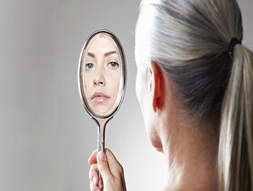 photo of a woman looking in a mirror