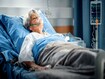 Hospital Ward: Portrait of Beautiful Elderly Woman Wearing Oxygen Mask Sleeping in Bed, Fully Recovering after Sickness. Old Lady Dreaming of Her Family, Friends, Happy Life.