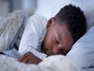 photo of young black Boy (6-7) sleeping in bed