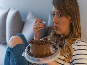 photo of Depressed woman eats cake 