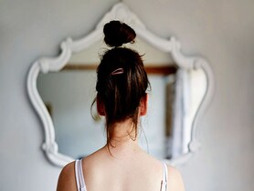 photo of Young woman looking in the mirror