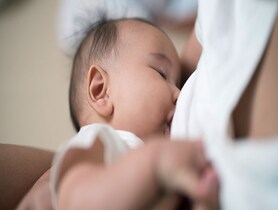 photo of Close-Up of mother breastfeeding baby boy