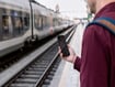 photo of Man using smartphone on a train station