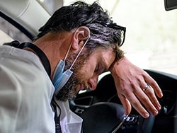 photo of Tired and exhausted doctor sitting in car