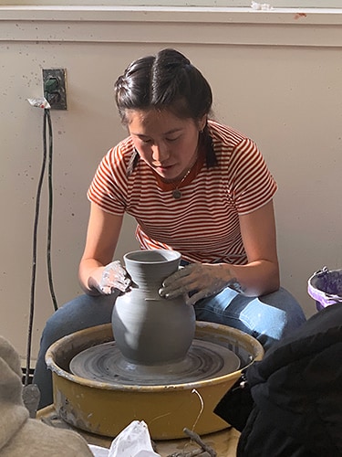 photo of Rebecca Ho at work in the ceramics studio