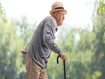 Senior man walking with a cane.